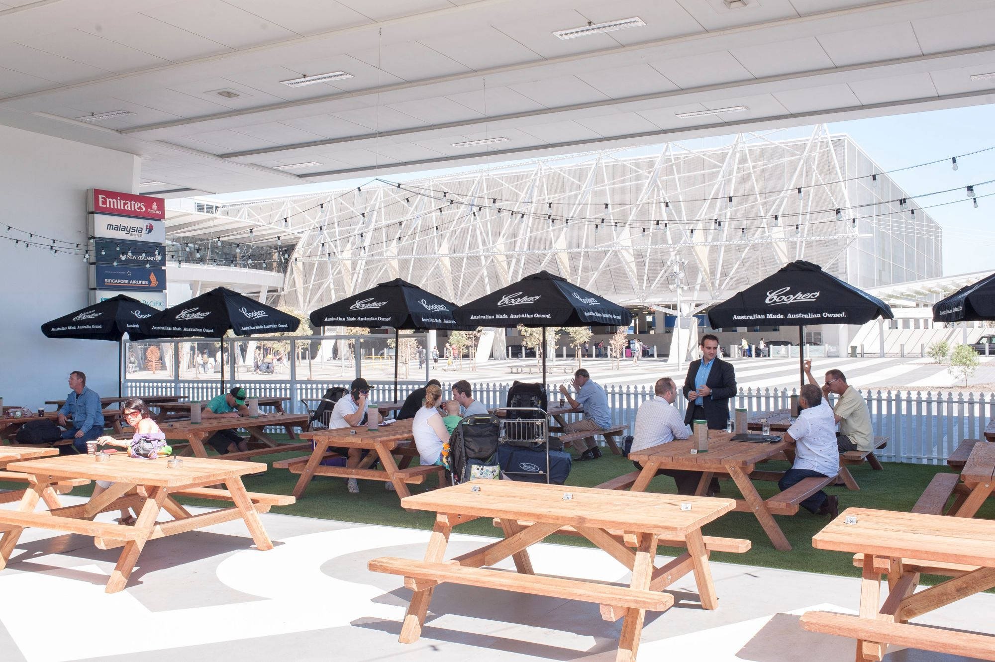 School courtyard with hardwood outdoor tables under a native canopy